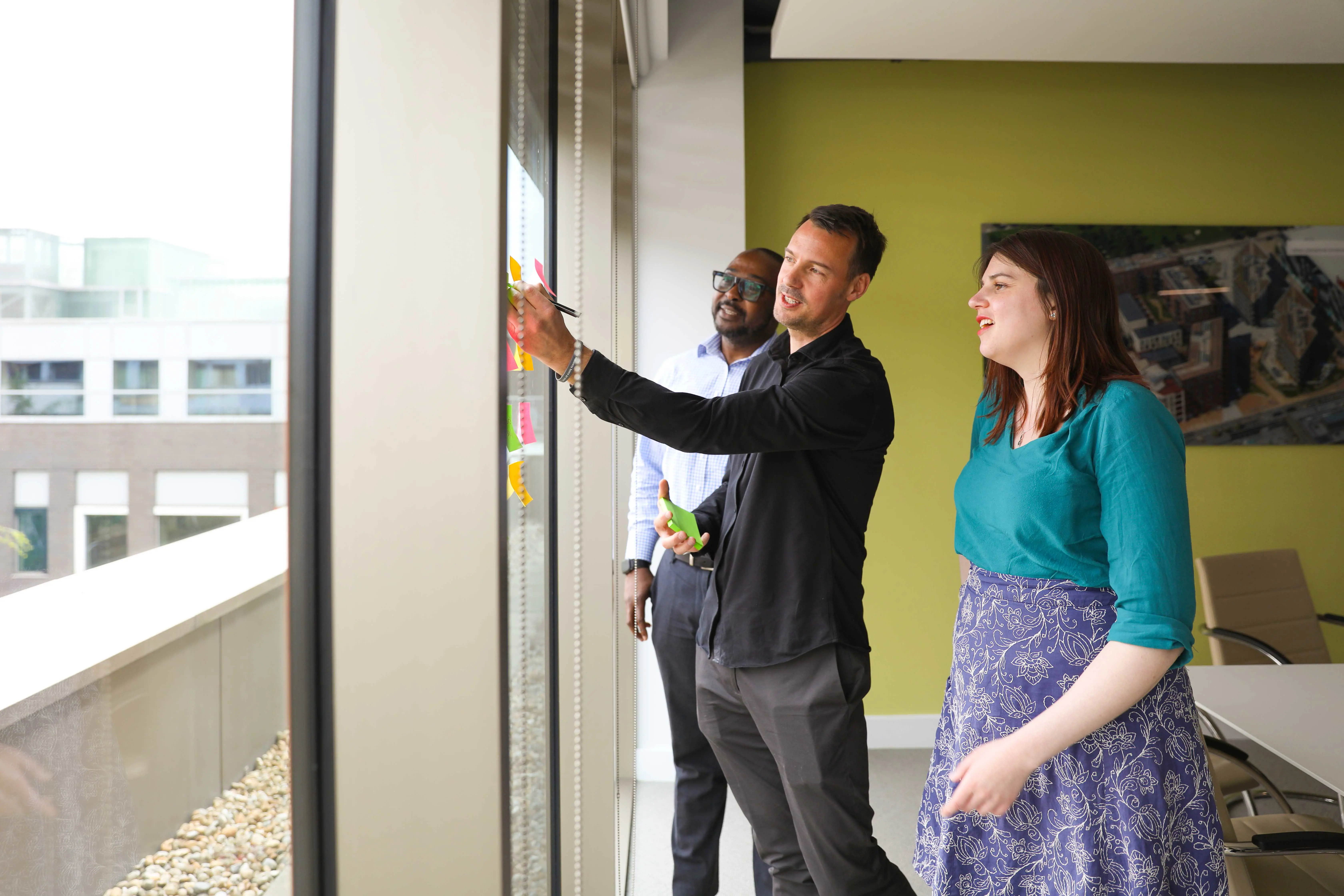 Three office-based colleagues mapping out project plans
